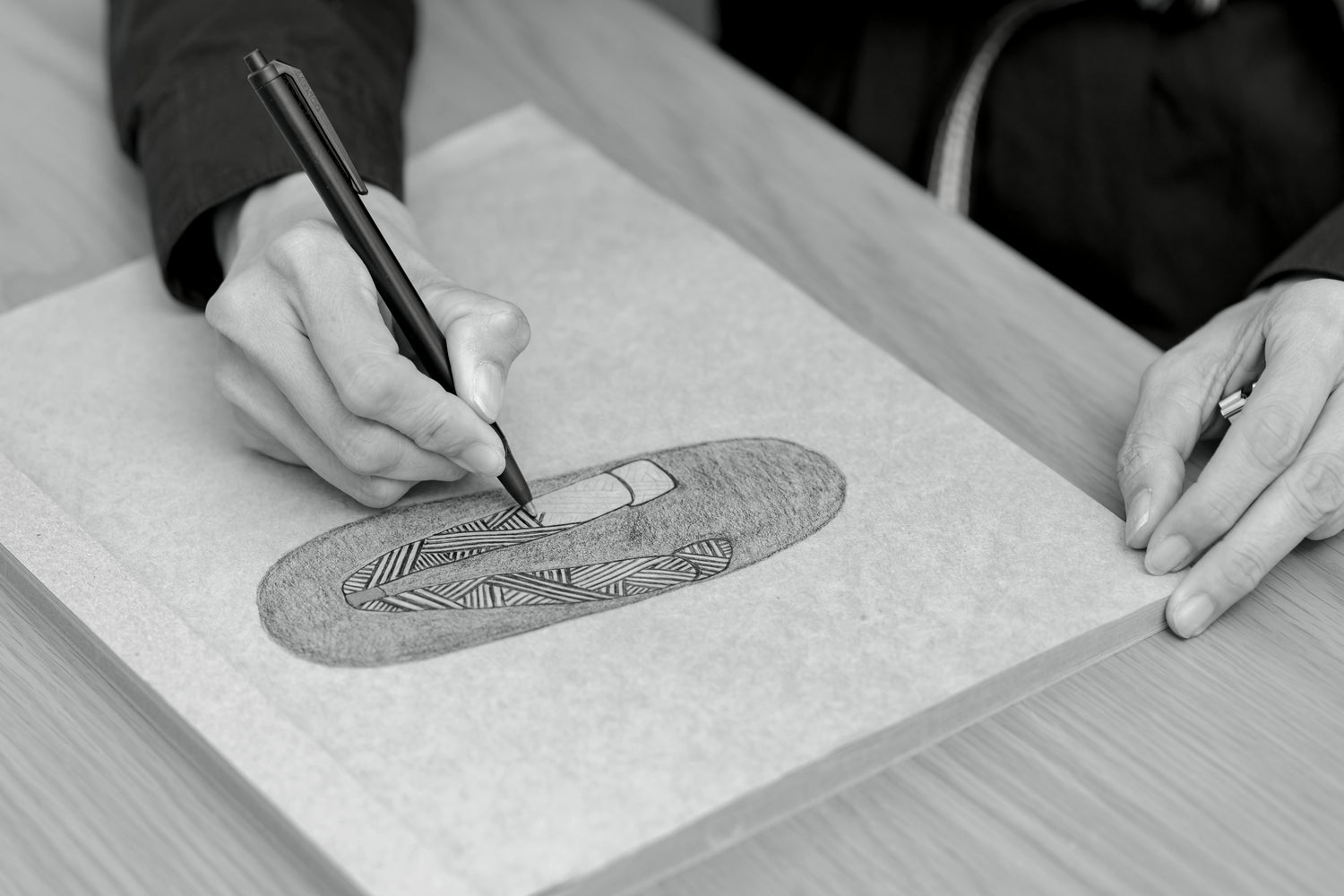 A craftsman designing zori slippers using knitted fabric.